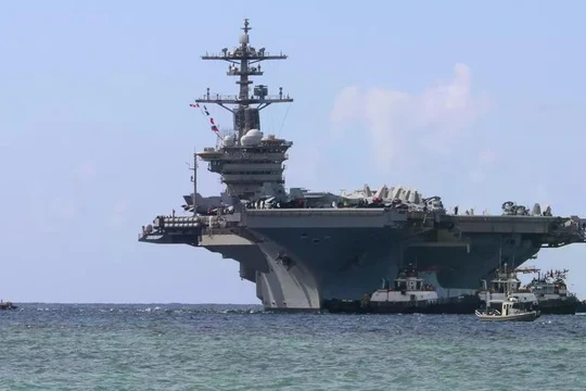 Các tàu kéo cảng dẫn đường cho tàu sân bay lớp Nimitz USS Abraham Lincoln khi tàu tiến vào Căn cứ Hải quân Mỹ ở Guam để thực hiện chuyến thăm cảng theo lịch trình, ngày 11/12/2025. Ảnh: Getty.
