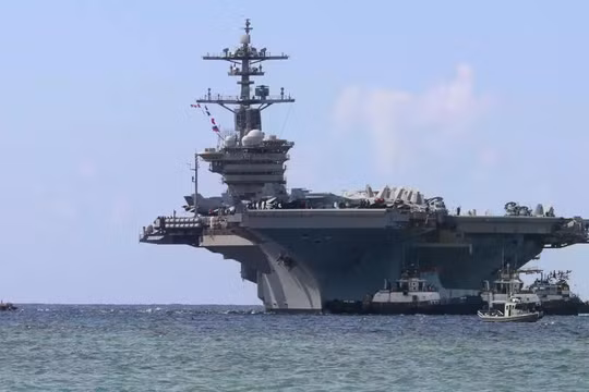 Các tàu kéo cảng dẫn đường cho tàu sân bay lớp Nimitz USS Abraham Lincoln khi tàu tiến vào Căn cứ Hải quân Mỹ ở Guam để thực hiện chuyến thăm cảng theo lịch trình, ngày 11/12/2025. Ảnh: Getty.