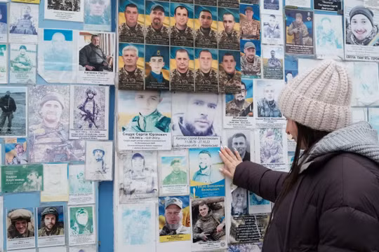 Bà Oksana Borkun ngắm nhìn bức chân dung chồng mình trên bức tường tưởng niệm những người lính Ukraine đã hy sinh ở Kiev, Ukraine. Ảnh: CNN.