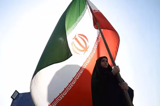 Một người phụ nữ cầm cờ Iran trên đường phố Tehran, Iran, ngày 10/6. Ảnh: Reuters.