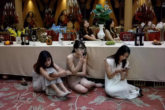 Các diễn viên chờ đợi trên phim trường của một bộ phim ngắn trong một buổi quay phim tại một hội trường tiệc ở Trịnh Châu, tỉnh Hà Nam, ngày 16/7/2024. Ảnh: Reuters.