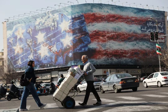 Người dân đi ngang qua một bảng quảng cáo chống Mỹ ở Tehran, Iran ngày 19/2. Ảnh: Reuters.