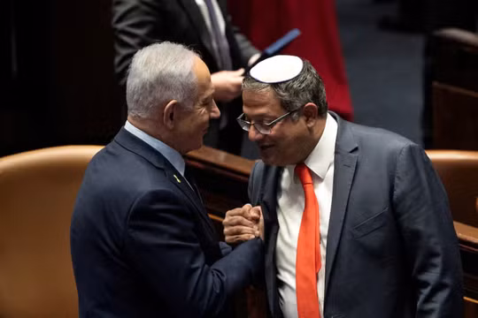 Thủ tướng Israel Benjamin Netanyahu và ông Itamar Ben-Gvir bắt tay nhau khi chính phủ Israel thông qua đề xuất của ông Netanyahu về việc bổ nhiệm lại ông Ben-Gvir làm Bộ trưởng An ninh Quốc gia, ngày 19/3. Ảnh: Reuters.