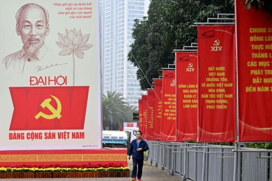Một người đàn ông đi ngang qua bảng quảng cáo Đại hội Đảng Cộng sản Việt Nam lần thứ 14 bên ngoài Trung tâm Hội nghị Quốc gia ở Hà Nội vào ngày 15/1. Ảnh: AFP.
