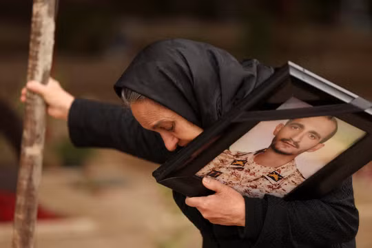 Bà Marzia Rezaei xúc động khi đứng gần mộ con trai mình, Erfan, người đã thiệt mạng trong một cuộc không kích, tại nghĩa trang Behesht-e Zahra, ở Tehran ngày 16/3. Ảnh: Reuters.