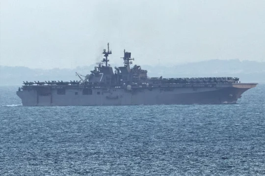 Tàu tấn công đổ bộ USS Tripoli (LHA-7) tiến vào eo biển Singapore, nhìn từ Singapore, hôm thứ Ba, ngày 17/ 3. Ảnh: Reuters.