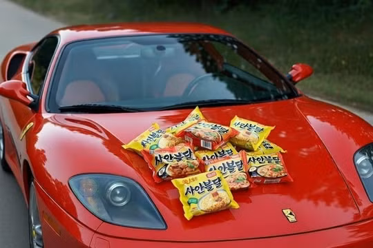 Những gói mì có giá phải chăng được đặt trên một chiếc Ferrari trong bức ảnh "thử thách nghèo đói" ở Hàn Quốc. Ảnh: OC.
