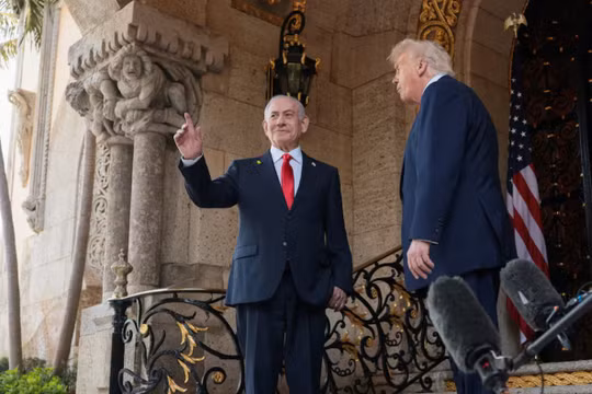 Thủ tướng Israel Benjamin Netanyahu ra hiệu khi được Tổng thống Mỹ Donald Trump chào đón trong các cuộc gặp tại câu lạc bộ Mar-a-Lago ở Palm Beach, Florida, Mỹ, ngày 29/12. Ảnh: Reuters.