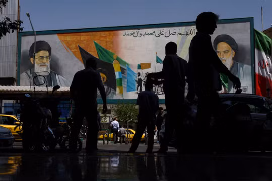 Người dân đi ngang qua một bức tranh tường mô tả cố lãnh đạo Cách mạng Hồi giáo, Ayatollah Ruhollah Khomeini, và cố lãnh đạo tối cao của Iran, Ayatollah Ali Khamenei, tại Tehran, Iran. Ảnh: Reuters.