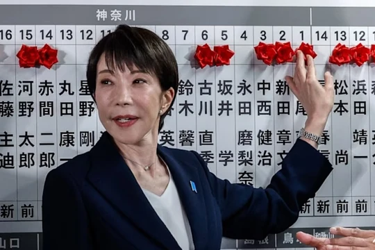 Thủ tướng Nhật Bản kiêm Chủ tịch Đảng Dân chủ Tự do (LDP) Sanae Takaichi đặt một bông hồng giấy màu đỏ lên tên của một ứng cử viên trúng cử tại trụ sở LDP trong cuộc bầu cử Hạ viện ở Tokyo ngày 8/2. Ảnh: AFP.