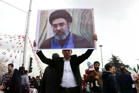 Một người đàn ông Iran cầm bức ảnh của ông Mojtaba Khamenei, con trai của lãnh đạo tối cao Iran lúc bấy giờ, trong lễ kỷ niệm 47 năm cuộc cách mạng Hồi giáo ở Tehran, Iran ngày 11/2. Ảnh: EPA.