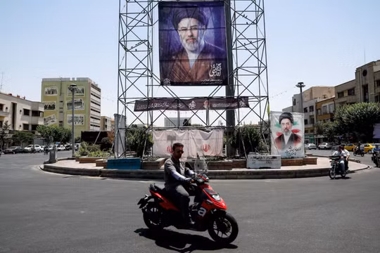 Người dân đi xe ngang qua một biểu ngữ có hình ảnh Lãnh tụ tối cao của Iran, Mojtaba Khamenei, tại Tehran, Iran, ngày 28/6. Ảnh: Reuters.