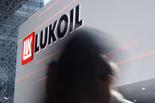 Một người đi ngang qua logo của Lukoil trong sự kiện thường niên Triển lãm và Hội nghị Dầu khí Quốc tế Abu Dhabi (ADIPEC) tại Abu Dhabi, UAE ngày 3/11/2025. Ảnh: Reuters.