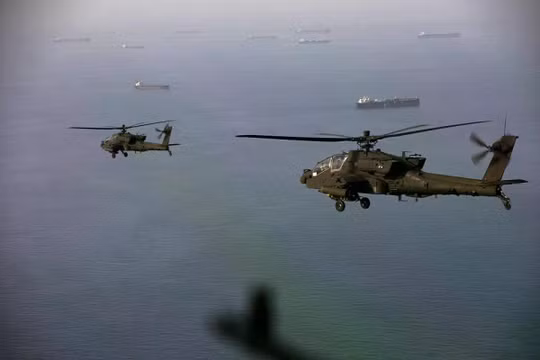 Máy bay trực thăng AH-64 Apache bay phía trên eo biển Hormuz trong một cuộc tuần tra vào ngày 17/4. Ảnh: AFP.