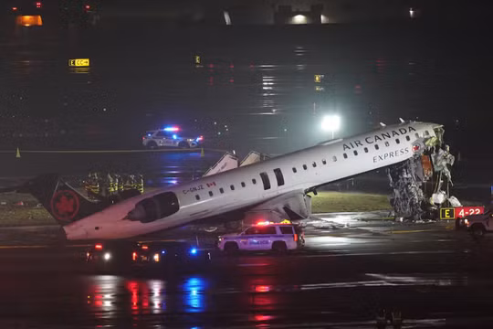 Các đội cứu hộ đang làm việc xung quanh chiếc máy bay Air Canada Express sau va chạm với một phương tiện trên mặt đất tại sân bay LaGuardia ở Queens, New York, Mỹ ngày 23/3. Ảnh: Reuters.