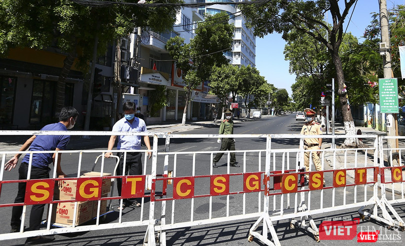 Người bên trong khu cách ly ra lấy hàng sau hệ thống rào chắn