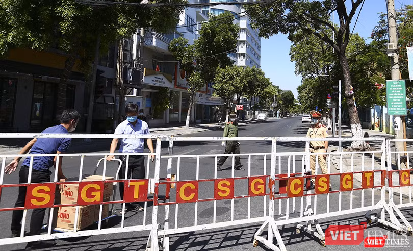 Người bên trong khu cách ly ra lấy hàng sau hệ thống rào chắn