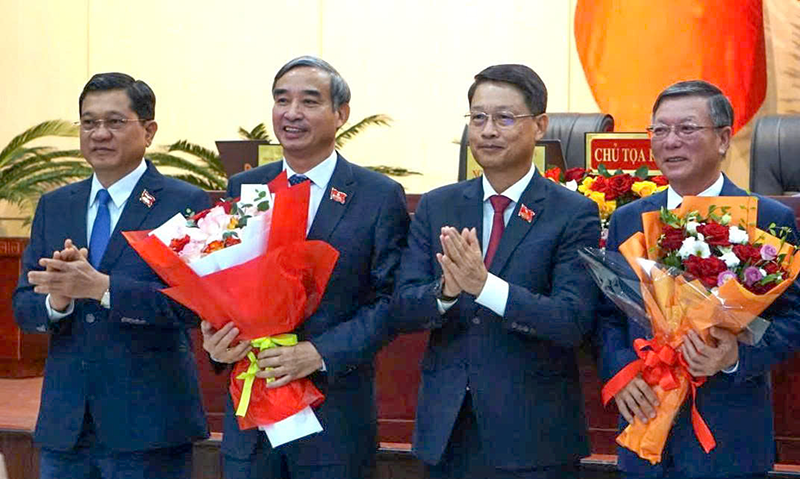 Đại diện HĐND TP tặng hoa cho ông Lê Trung Chinh (thứ 2 từ trái sang), Chủ tịch UBND TP Đà Nẵng và ông Lê Văn Trung (bìa phải), Chủ tịch Ủy ban Mặt trận Tổ quốc Việt Nam TP Đà Nẵng.