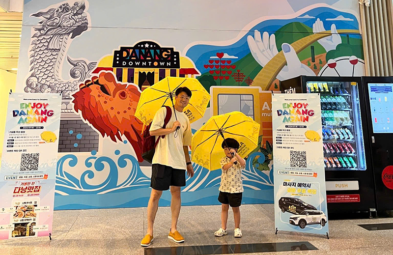 Du khách Hàn Quốc thích thú với chiếc dù có logo, hình ảnh du lịch Đà Nẵng