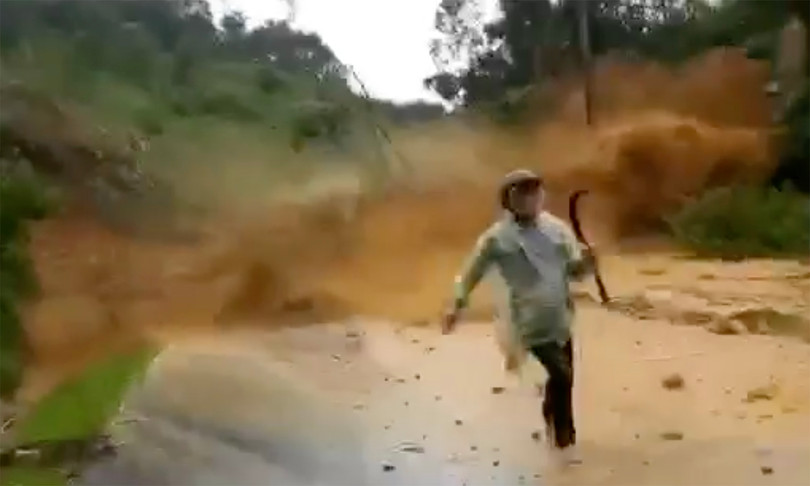 Người đi đường thất thần tháo chạy khỏi đống đất đá từ trên cao đổ xuống (ảnh cắt từ clip)