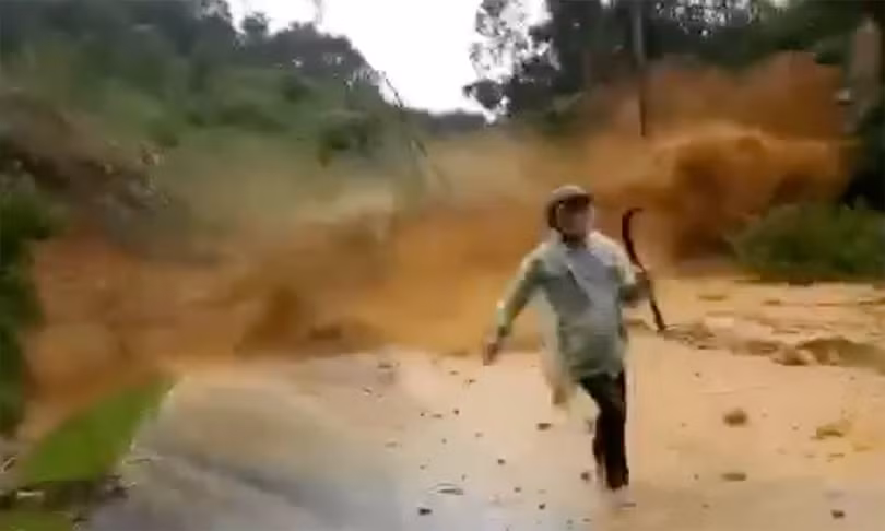 Người đi đường thất thần tháo chạy khỏi đống đất đá từ trên cao đổ xuống (ảnh cắt từ clip)