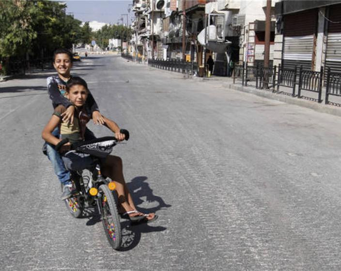 Hai bé trai trên đường phố Aleppo Syria ngày 15/9/2016. Ảnh: Cankao