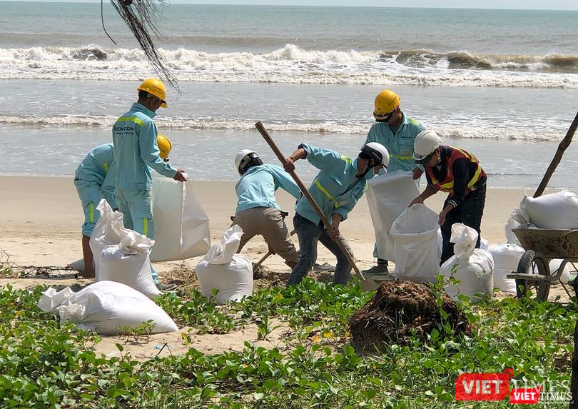 Công nhân công trình xúc cát để chèn mái công trình