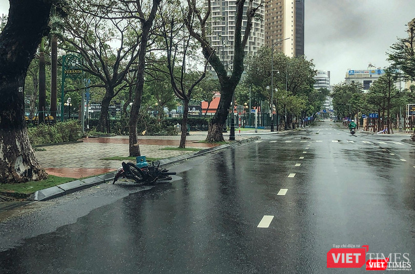 Một người đi đường phải vứt xe vì gió thổi quá mạnh