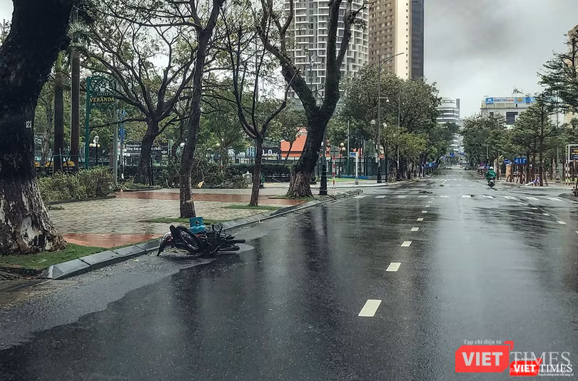 Một người đi đường phải vứt xe vì gió thổi quá mạnh