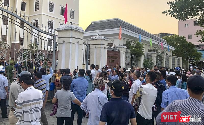 Khách hàng liên quan đến vụ án đứng trước cổng toà án chờ phán quyết của toà