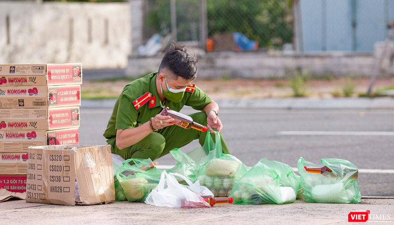 Chiến sĩ trẻ soát lại đơn hàng nhu yếu phẩm của người dân trước khi giao (Ảnh: Nghĩa Hiếu)
