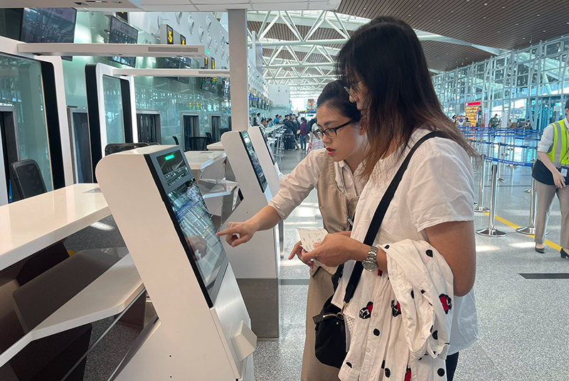 Nhân viên hướng dẫn hành khách sử dụng dịch vụ ký gửi hành lý tự động thông qua việc tích hợp hệ thống quầy tự gửi hành lý (self-bag drop) tại Nhà ga T2 Đà Nẵng