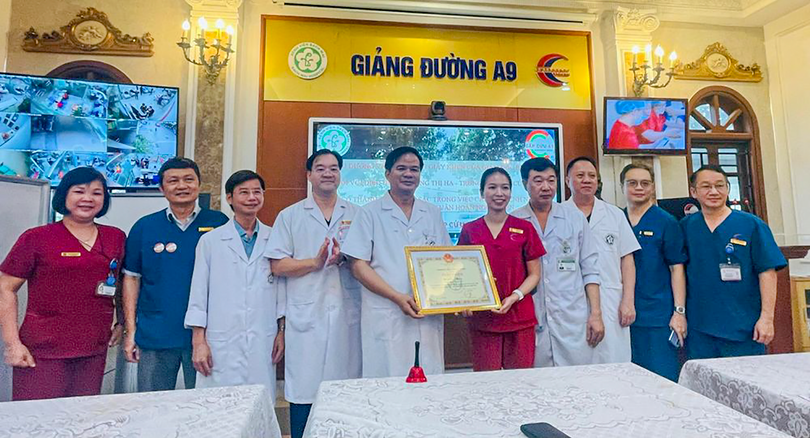 PGS.TS Đào Xuân Cơ, Giám đốc Bệnh viện Bạch Mai, trao giấy khen và thưởng "nóng" nữ điều dưỡng Đặng Thị Hạ. (ảnh Thái Bình).