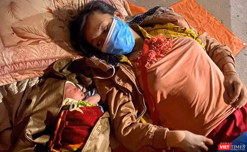 Mẹ con bé trai 10 ngày tuổi nằm nghỉ bên hiên nhà trong chuyền hành trình hơn 1.400km từ TP HCM về quê đi ngang qua Đà Nẵng (ảnh Minh Việt)