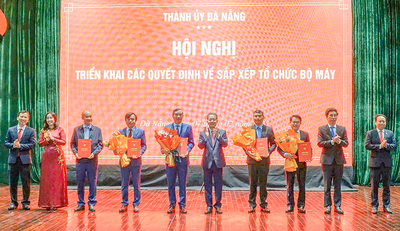 Ông Nguyễn Văn Quảng (thứ 5 từ phải sang), Bí thư Thành ủy Đà Nẵng trao quyết định cho ông Lê Trung Chinh (thứ 5 từ trái sang) và các cá nhân tại hội nghị.