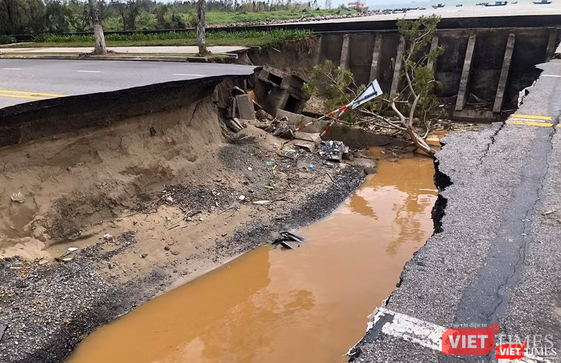 Một chiếc xe máy bị nước lũ cuốn trôi xuống vết xói lở