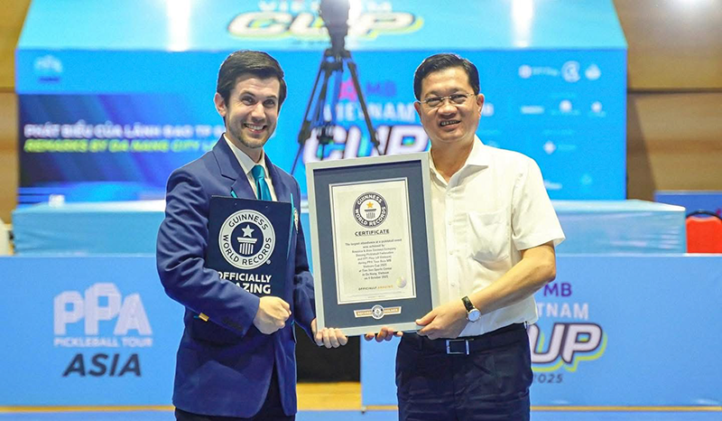 Đại diện Tổ chức Guinness World trao chứng nhận kỷ lục cho ông Trần Phước Sơn, Chủ tịch Liên đoàn Pickleball Đà Nẵng. Ảnh DPF