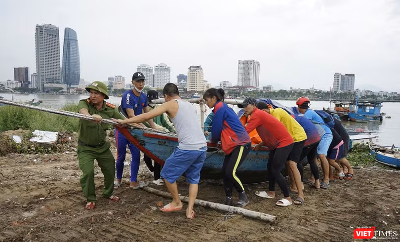 Lực lượng công an hỗ trợ người dân đưa tàu thuyền lên bờ tránh bão
