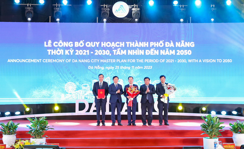 Phó Thủ tướng Chính phủ Trần Hồng Hà (thứ hai từ trái qua) và Bộ trưởng Bộ KH&ĐT Nguyễn Chí Dũng (thứ hai từ phải qua) trao quyết định phê duyệt của Chính phủ Quy hoạch TP Đà Nẵng thời kỳ 2021 - 2030, tầm nhìn đến năm 2050 của Chính phủ cho lãnh đạo TP Đà Nẵng