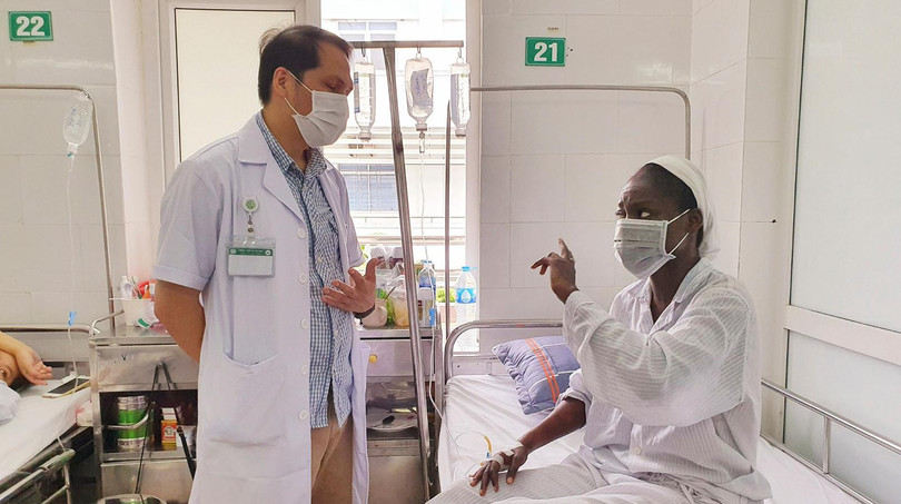 Bác sĩ Trung tâm Bệnh nhiệt đới Bệnh viện Bạch Mai trò chuyện, động viên bệnh nhân bị sốt rét ác tính trong những ngày điều trị (ảnh BV cung cấp)