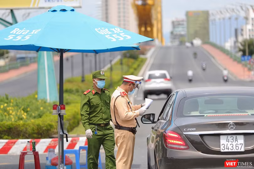 Lực lượng công an tại chốt kiểm soát dịch trên địa bàn TP Đà Nẵng kiểm tra giấy đi đường của người dân