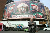 Người dân Iran đi ngang qua một bảng quảng cáo tại quảng trường Valiasr ở Tehran, Iran ngày 22/3. Ảnh: EPA.