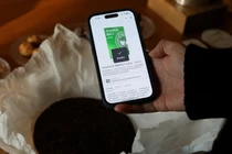 Eric Ma, người sáng lập kiêm CEO của Teaken, đang quét mã vạch một bánh trà bằng ứng dụng trên điện thoại thông minh tại quán trà Bei ở Thượng Hải, Trung Quốc, ngày 15/12. Ảnh: Reuters.