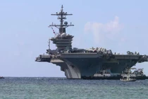 Các tàu kéo cảng dẫn đường cho tàu sân bay lớp Nimitz USS Abraham Lincoln khi tàu tiến vào Căn cứ Hải quân Mỹ ở Guam để thực hiện chuyến thăm cảng theo lịch trình, ngày 11/12/2025. Ảnh: Getty.