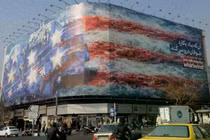 Một biểu ngữ khổng lồ được trưng bày tại Quảng trường Cách mạng mô tả vụ tấn công tên lửa vào tàu sân bay của Mỹ, được sơn màu cờ Mỹ vào ngày 26/1 tại Tehran, Iran. Ảnh: Newsweek.