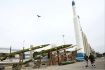 Người dân đi dạo gần các tên lửa của Iran trong một công viên tại Tehran, Iran ngày 26/3 Ảnh: Reuters.