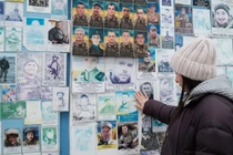 Bà Oksana Borkun ngắm nhìn bức chân dung chồng mình trên bức tường tưởng niệm những người lính Ukraine đã hy sinh ở Kiev, Ukraine. Ảnh: CNN.