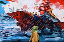 Một người phụ nữ đi ngang qua bức tranh tường phản đối lực lượng Mỹ và Israel ở Tehran, Iran ngày 8/4. Ảnh: AFP.