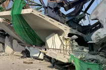 Một chiếc ô tô bẹp dúm nằm giữa đống đổ nát sau khi một cần cẩu sập tại công trình đường cao tốc Rama II đang thi công, hôm 15/1. Ảnh: Xinhua.