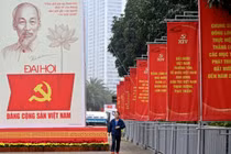 Một người đàn ông đi ngang qua bảng quảng cáo Đại hội Đảng Cộng sản Việt Nam lần thứ 14 bên ngoài Trung tâm Hội nghị Quốc gia ở Hà Nội vào ngày 15/1. Ảnh: AFP.